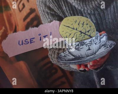 Konzeptuelle, selbst gemachte Collage-Kunst einer Hand, die einen Becher mit einem Hirn in sich hält und die Botschaft „Use IT!“ Stockfoto