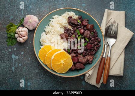 Feijoada, traditioneller brasilianischer Eintopf mit schwarzen Bohnen, Reis und Orangenscheiben, Blick von oben Stockfoto