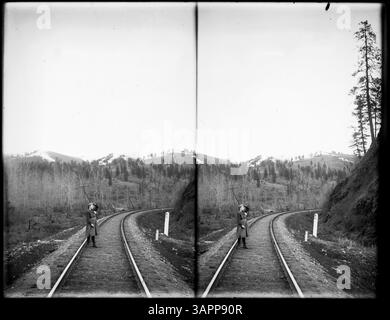 Ein stereoskopisches Foto einer Frau, die auf Eisenbahngleisen steht. Dieses Bild fängt einen einzigartigen Moment in der Fotografie des frühen 20. Jahrhunderts ein. Stockfoto