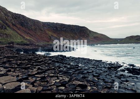 Sturmwellen treffen mit dunklem Himmel auf die Giant’s Causeway Rocks Stockfoto
