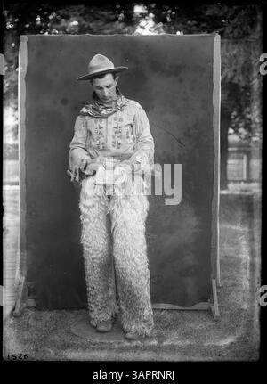 Dieses Porträtfoto in voller Länge, beschriftet mit PH036 1526, zeigt Glen Bushee, einen Cowboy, der in voller Kleidung steht. Das Bild zeigt eine wichtige Figur des westlichen Lebens und der westlichen Kultur. Stockfoto