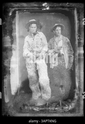 Dieses Foto von Lee Moorhouse zeigt Glen Bushee, einen Cowboy, der mit einem anderen Cowboy steht. Das abendfüllende Porträt zeigt die Cowboykultur im amerikanischen Westen und hebt die Mode und den Lebensstil der damaligen Zeit hervor. Stockfoto