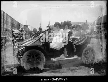 Foto eines frühen Modellautos, dekoriert für eine Parade, mit fünf Frauen innen, die eine Parade aus dem frühen 20. Jahrhundert in Pendleton aufnehmen. Stockfoto