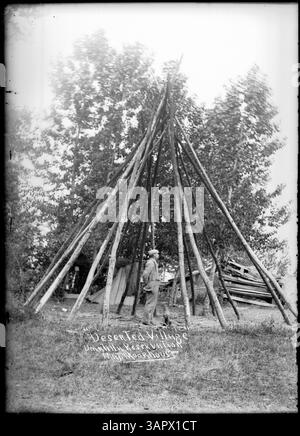 Foto aus Lee Moorhouse's Sammlung, das ein verlassenes Dorf auf der Umatilla Reservation mit einem Mann in einem Tipi-Rahmen darstellt, der die Geschichte der indigenen Siedlungen widerspiegelt. Stockfoto