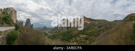 Panoramablick auf Meteora mit den Klöstern Roussanou, Agios Nikolaos und Varlaam auf Felsen und bewölktem Himmel, Kalambaka, Thessalien, Griechenland Stockfoto