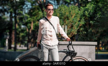 Portrait eines Hipster-Geschäftsmannes in Sonnenbrille mit Fahrradstand Stockfoto
