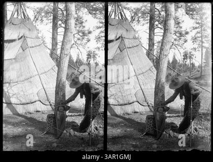 Foto eines Mannes mit einem Papoose vor einem Tipi, das das Familienleben und die Tradition der Ureinwohner Amerikas darstellt. Stockfoto