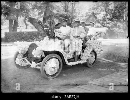 Ein Foto von Lee Moorhouse von einer Autoparade in Pendleton, Oregon. Das Bild zeigt fünf Männer in einem dekorierten Auto mit Hühnern auf der Motorhaube, die eine Tradition der Parade aus dem frühen 20. Jahrhundert in der Region zeigen. Stockfoto