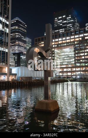 Nächtlicher Blick auf moderne Skulpturen und Wolkenkratzer in Canary Wharf Stockfoto