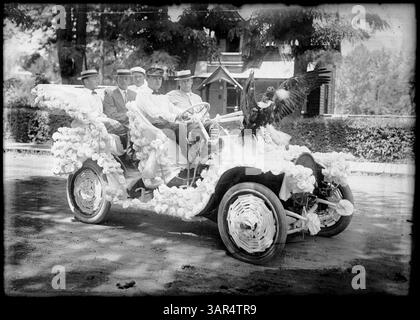 Dieses Foto von Lee Moorhouse zeigt eine Automobilparade in Pendleton, Oregon, mit fünf Männern in einem Auto mit weißen Rosetten und einem Geflügel auf der Motorhaube. Stockfoto