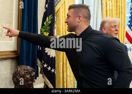 Tim Tebow wies auf eine Unterschrift auf einer Kopie der Unabhängigkeitserklärung hin, die im Oval Office des Weißen Hauses während eines Treffens mit Präsident Donald Trump am 1. April 2025 gehängt wurde. (USA) Stockfoto