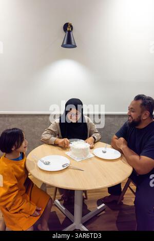 Asiatische muslimische Familie feiert zu Hause gemeinsam Geburtstag. Stockfoto