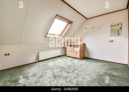 Ein Zimmer mit Dachboden und Oberlichtern auf dem Dach ist ein sehr hellgrüner Teppich Stockfoto