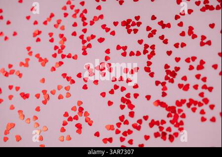Rot glänzende Herzen auf weichem rosa Hintergrund, perfekt für Valentinstag, Liebe Stockfoto