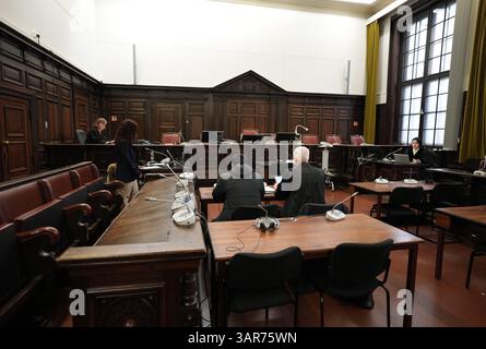 Hamburg, Deutschland. April 2025. Der Angeklagte (M, l) wartet neben seinem Anwalt im Gerichtssaal des Strafrechtsgebäudes auf den Beginn des Verfahrens wegen tödlicher Messerstechungen am U-Bahnhof Billstedt. Am 19. August 2024 erstichen der Angeklagte und andere Komplizen in der U-Bahn-Station Billstedt fünf Mal auf einen Mann. Der Angeklagte soll mindestens einen Messerstecher vollzogen haben. Das Opfer starb am Tatort. Quelle: Marcus Brandt/Pool/dpa/Alamy Live News Stockfoto