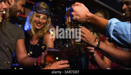 Bild von Goldsternen über Freunden, die Toast machen und feiern Stockfoto