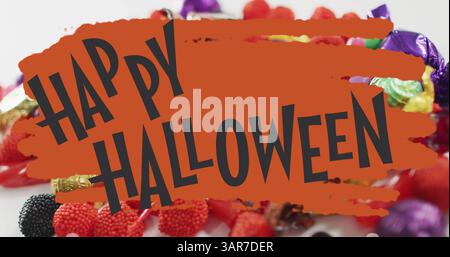 Happy halloween Textbanner mit fliegenden Fledermaussymbolen gegen schauriges Augenspielzeug und halloween-Bonbons Stockfoto