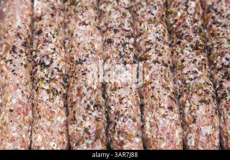 Rohes Hackfleisch, gegrillt auf Holzspießen. Lula Kebab auf einem Grillgitter. Stockfoto