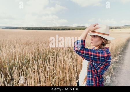Frau auf einem Weizenfeld mit Strohhut Stockfoto