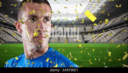 Goldenes Konfetti fällt über den männlichen kaukasier, der einen Rugbyball gegen das Sportstadion hält Stockfoto