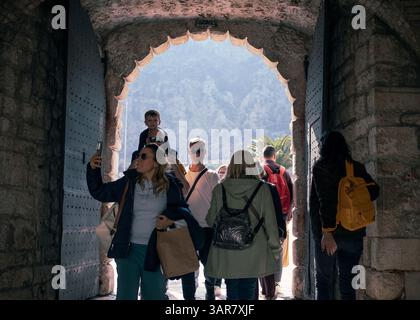 Montenegro, 30. März 2025: Touristen passieren das historische Seetor, um in die Altstadt von Kotor zu gelangen. Stockfoto