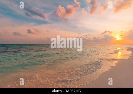 Goldener Sonnenuntergang, strahlende Wolken. Ruhige Meereswellen an tropischer Küste. Paradies Urlaubsszene Küste wunderschön. Inspiration für den Sommer Stockfoto
