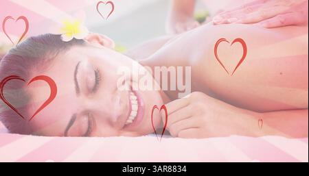 Bild von Herzen, die während der Massage über die kaukasierin fallen Stockfoto