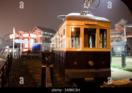 Peking, China, 14.07.2010. Ein Trolley steht vor einem Gebäude mit einem Schild mit der Aufschrift „Rice“. Die Szene spielt nachts, mit dem Trolley Stockfoto