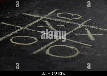 Kinderspiel Tic-Tac-Toe auf einer Schultafel gezeichnet, Spiel Tic-Tac-Toe Stockfoto
