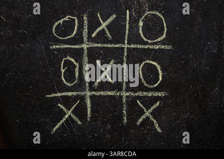 Kinderspiel Tic-Tac-Toe auf einer Schultafel gezeichnet, Spiel Tic-Tac-Toe Stockfoto