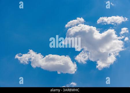 Sonniger Tag mit klarem blauem Himmel und weichen weißen Wolken, perfekt für friedliche Naturszenen, Outdoor-Hintergründe und helles Sommerwetter-Inspiration Stockfoto