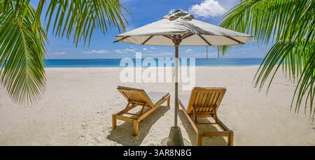 Sonnenliegen Sonnenschirme perfekt für romantische Paare im Urlaub. Entspannende Atmosphäre am Meer, warme Sonne und traumhafter tropischer Kurzurlaub Stockfoto
