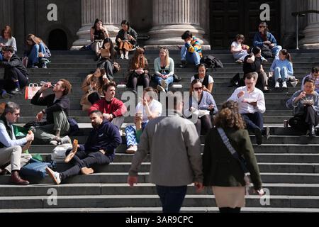 People enjoying their lunch on the steps of St Paul's Cathedral in central London. Bank holiday weekend will be mixture of sunshine and showers for most of the UK while south-west England should brace for heavy downpours, forecasters have said. Picture date: Thursday April 17, 2025. Stockfoto
