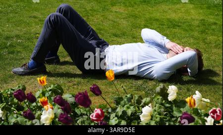 A person enjoys the warm weather in Festival Gardens at St. Paul's Cathedral in central London. Bank holiday weekend will be mixture of sunshine and showers for most of the UK while south-west England should brace for heavy downpours, forecasters have said. Picture date: Thursday April 17, 2025. Stockfoto