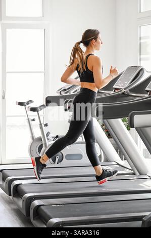 Frau, die drinnen joggt und sich auf Fitnessziele konzentriert Stockfoto