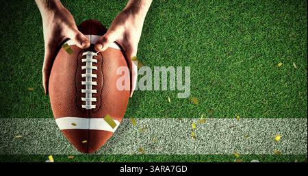 Bild von Goldkonfetti, die über einen Mann fallen, der Rugbyball im Sportstadion hält Stockfoto