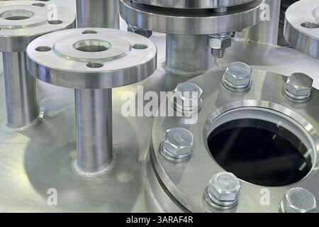 Verschiedene Teile von Hochdruckgeräten - Edelstahlrohre, Flansche und Stopfen, Nahaufnahme, abstrakter industrieller Hintergrund Stockfoto