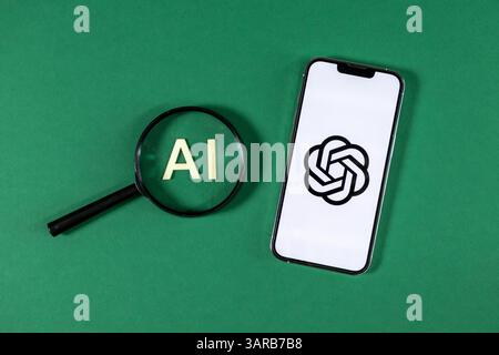 Posen, Polen – 14. April 2025: Smartphone mit ChatGPT-Logo neben Lupe über hölzernen KI-Buchstaben, symbolisiert den Fokus auf moderne Kunst Stockfoto