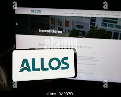 Stuttgart, Deutschland - 13.12.2024: Person, die ein Smartphone mit dem Logo des brasilianischen Immobilienentwicklungsunternehmens Allos SA auf dem Bildschirm hält Stockfoto