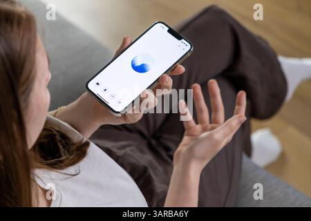 Posen, Polen – 14. April 2025: Eine Frau interagiert mit einem GPT-Sprachassistenten auf ihrem Smartphone und demonstriert den Einsatz künstlicher Intelligenz in d Stockfoto