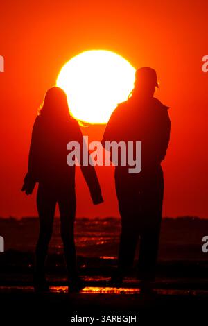 Isle Of Palms, Usa. April 2025. Strandbesucher werden vom Sonnenaufgang umgeben, während sie die Sonne vom Strand aus im Wild Dunes Resort am 17. April 2025 in Isle of Palms, South Carolina, beobachten. Quelle: Richard Ellis/Richard Ellis/Alamy Live News Stockfoto