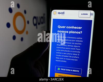 Stuttgart, Deutschland - 19.12.2024: Person mit Smartphone mit Webseite der brasilianischen Krankenkasse Qualicorp SA auf dem Bildschirm mit Logo. Stockfoto