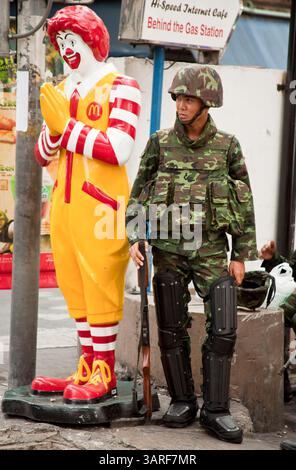 17. Mai 2010 - Bangkok, Thailand - Ein thailändischer Soldat im Dienst der McDonald's auf Sukhumvit in Soi 4 im Zentrum von Bangkok. Die thailändische Armee hat in Sukhumvit Positionen eingenommen, um regierungsfeindliche Demonstranten aus dem Gebiet fernzuhalten. Die regierungsfeindlichen Demonstranten kontrollieren bereits lange Strecken der beiden Hauptstraßen, die parallel zu Sukhumvit verlaufen, und machen Sukhumvit zum einzigen sicheren Zugang zum Zentrum Bangkoks. Die thailändische Regierung gab am Montag bekannt, dass der inoffizielle Militärkommandant und treue Unterstützer der Red Shirts, Generalmajor der thailändischen Armee, am Montag an Wunden starb, die er erlitt, als ein Scharfschütze Stockfoto