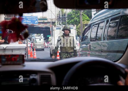 18. Mai 2010 - Bangkok, Thailand - Ein thailändischer Soldat an einer Straßensperre an der Sukhumvit Road in Bangkok. Dies ist der nächste Punkt zum Red Shirt Camp in Ratchaprasong Kreuzung und Menschen dürfen nicht daran vorbeikommen. Die gewaltsamen Unruhen in Bangkok gingen am Dienstag wieder an, fast eine Woche nachdem die thailändischen Truppen begannen, auf Demonstranten zu schießen und die Einwohner Bangkoks aus gewalttätigem Protest gegen die Regierung auf die Straße gingen. Der Dienstag war jedoch nicht so gewalttätig wie in den Vortagen. Obwohl die Demonstranten weiterhin Straßensperren und brennende Reifenbarrikaden in Teilen der Stadt errichteten, gab es nicht so viel Schussfeuer von Th Stockfoto
