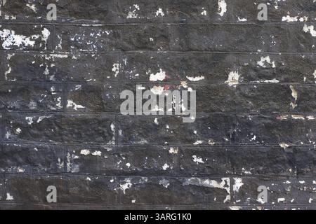 Ziegelwand in Schwarz mit Makeln ab und zu. Stockfoto