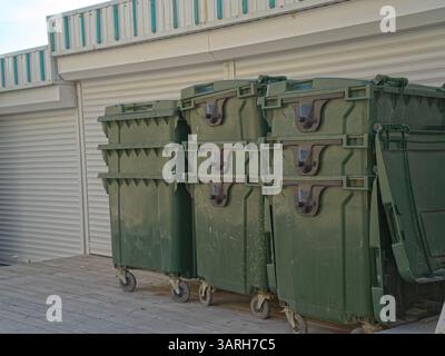 Grüner Abfallbehälter aus Kunststoff. Grüne Behälter zum Auffangen von Müll auf dem Mülleimer. Stockfoto