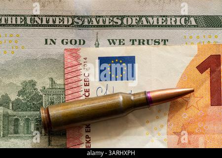 Die Kugel liegt auf den Dollar- und Euroscheine, und der Text auf dem Dollarschein steht in Gott, dem wir vertrauen, Geld für Waffen Stockfoto
