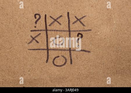 Kinderspiel Tic-Tac-Toe und Fragezeichen auf braunem Papier mit schwarzem Marker, Tic-Tac-Toe-Spiel Stockfoto