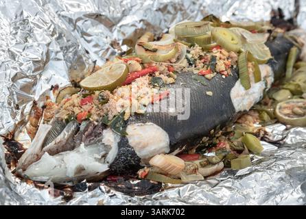Gebackener ganzer Lachs mit Kräutern im Ofen, Zutaten sind Korianderwurzel, Ingwer, Galangal, Kaffir-Limette, Lauch, gehackt und Bird's Eye Chil Stockfoto