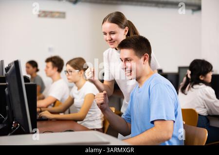Teenager-Mädchen hilft Freundin, Probleme am Computer in der Schule zu lösen Stockfoto